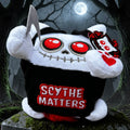Halloween-Emporium Squaredy Cats Grim Reaper plush toy with red eyes, black hooded cloak, and scythe on a tombstone.