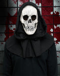 Halloween-Emporium grim reaper skull mask with attached black hood against a blood-spattered wall background