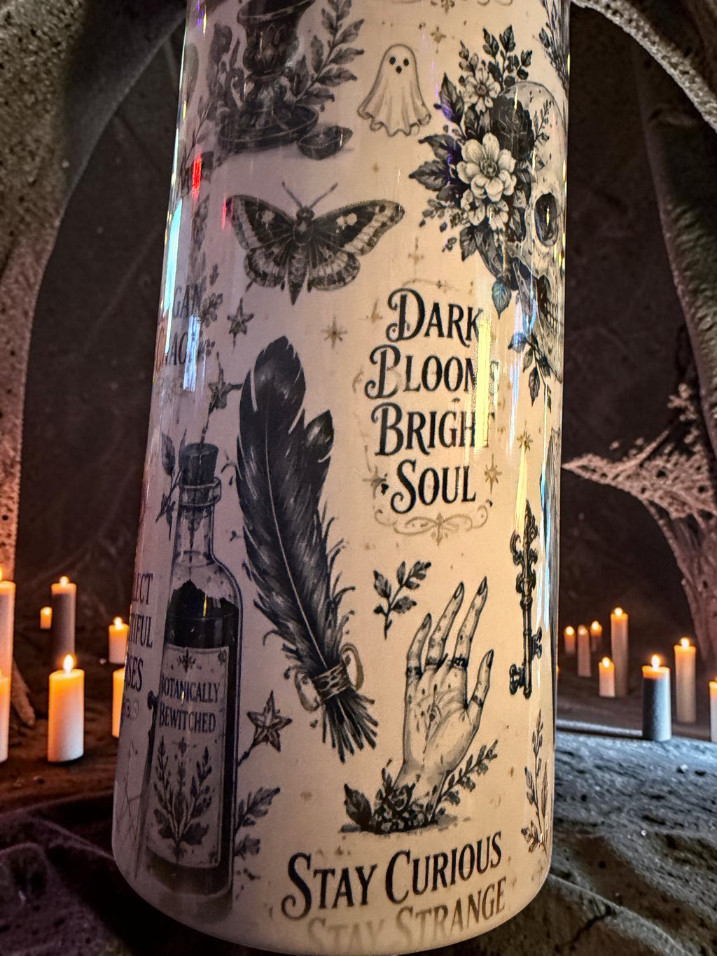 Halloween-Emporium 30oz grimoire tumbler with occult illustrations of skulls, moths, and potions on a cream background