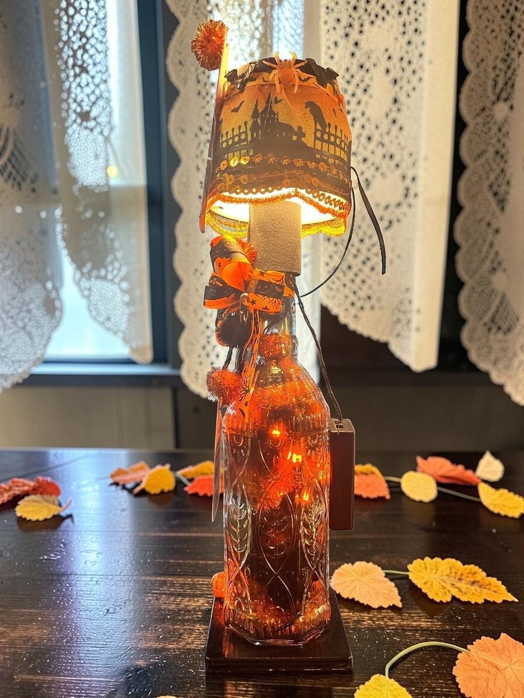 Halloween-Emporium handcrafted LED lamp by Randy Hendrickson featuring a spooky castle shade and glowing bottle base.