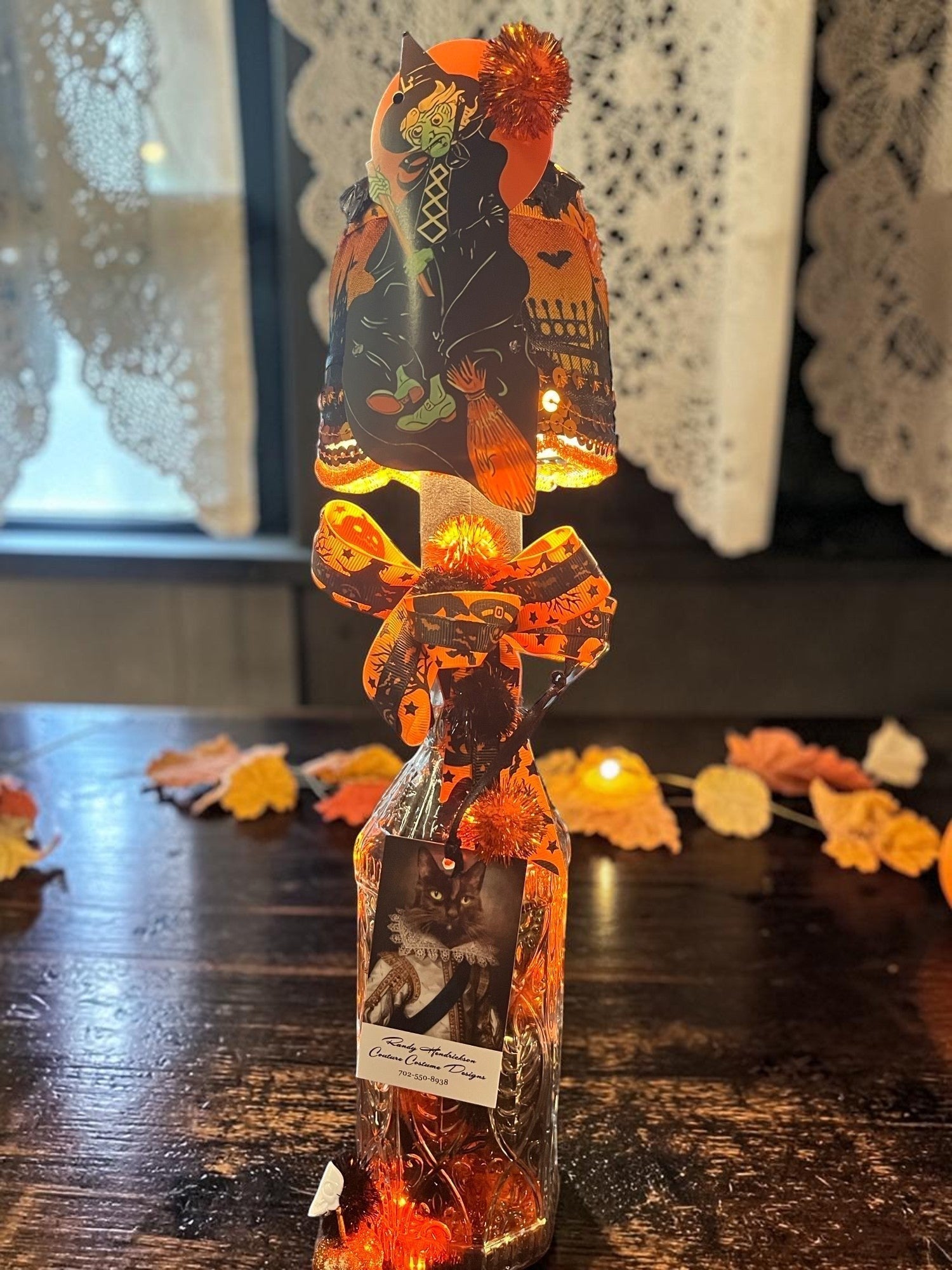 Halloween-Emporium handcrafted LED lamp by Randy Hendrickson featuring a witch theme, orange ribbon, and bottle base.