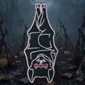 Halloween-Emporium hanging bat embroidered iron-on patch with white stitching and red eyes on a dark pumpkin patch