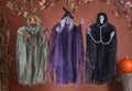 Halloween-Emporium hanging trio of pumpkin ghoul, witch, and grim reaper with tattered fabric and metallic chains.
