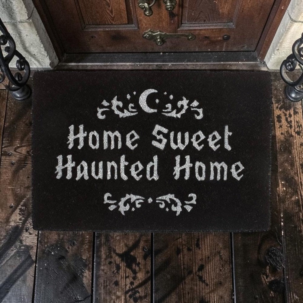 Halloween-Emporium natural grass doormat with Home Sweet Haunted Home text and moon design on a dark porch