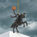 Halloween-Emporium Headless Horseman ornament featuring a rider on a black horse holding an axe and a glowing pumpkin.