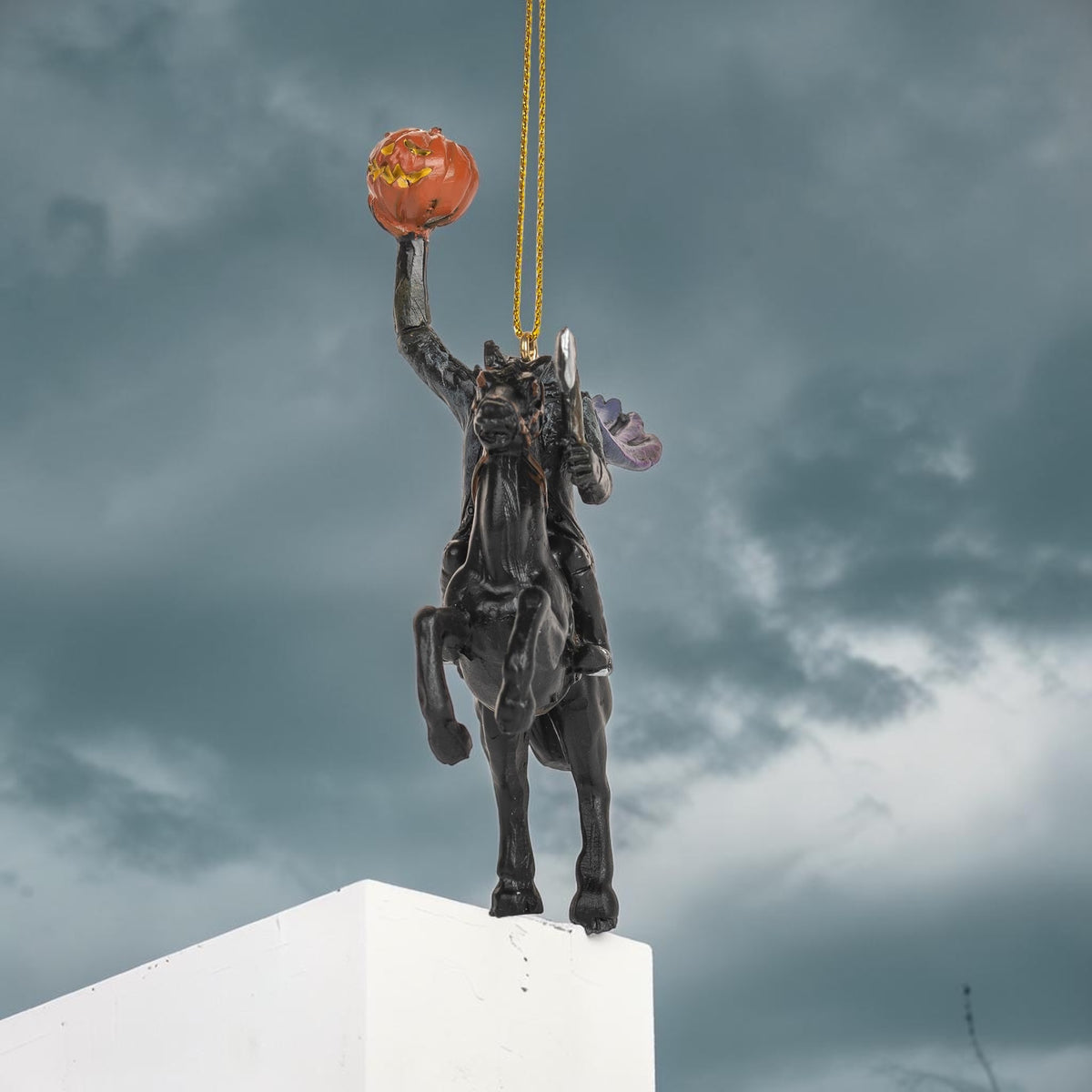 Halloween-Emporium Headless Horseman ornament featuring a black horse and rider holding a glowing orange jack-o-lantern.
