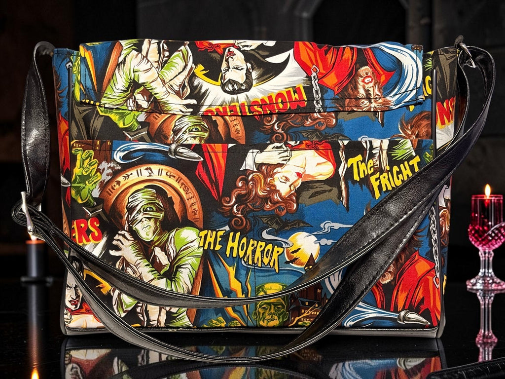 Halloween-Emporium messenger bag featuring a vibrant classic horror comic book print with monsters and gothic motifs.