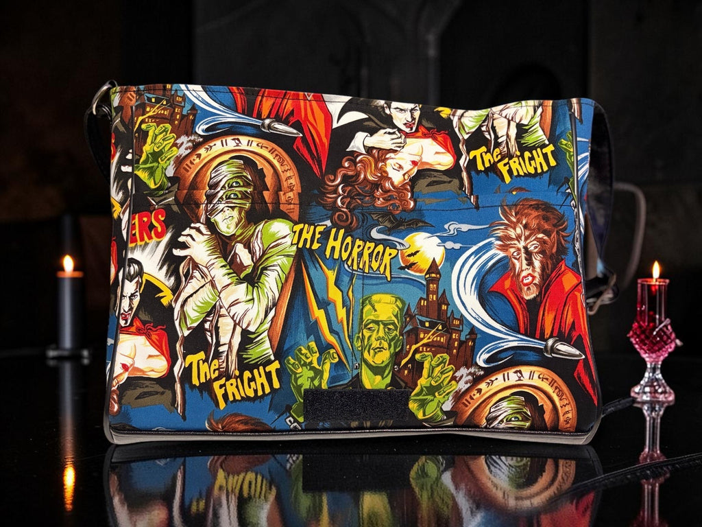 Halloween-Emporium messenger bag featuring a vibrant classic horror comic book print with monsters and gothic motifs.