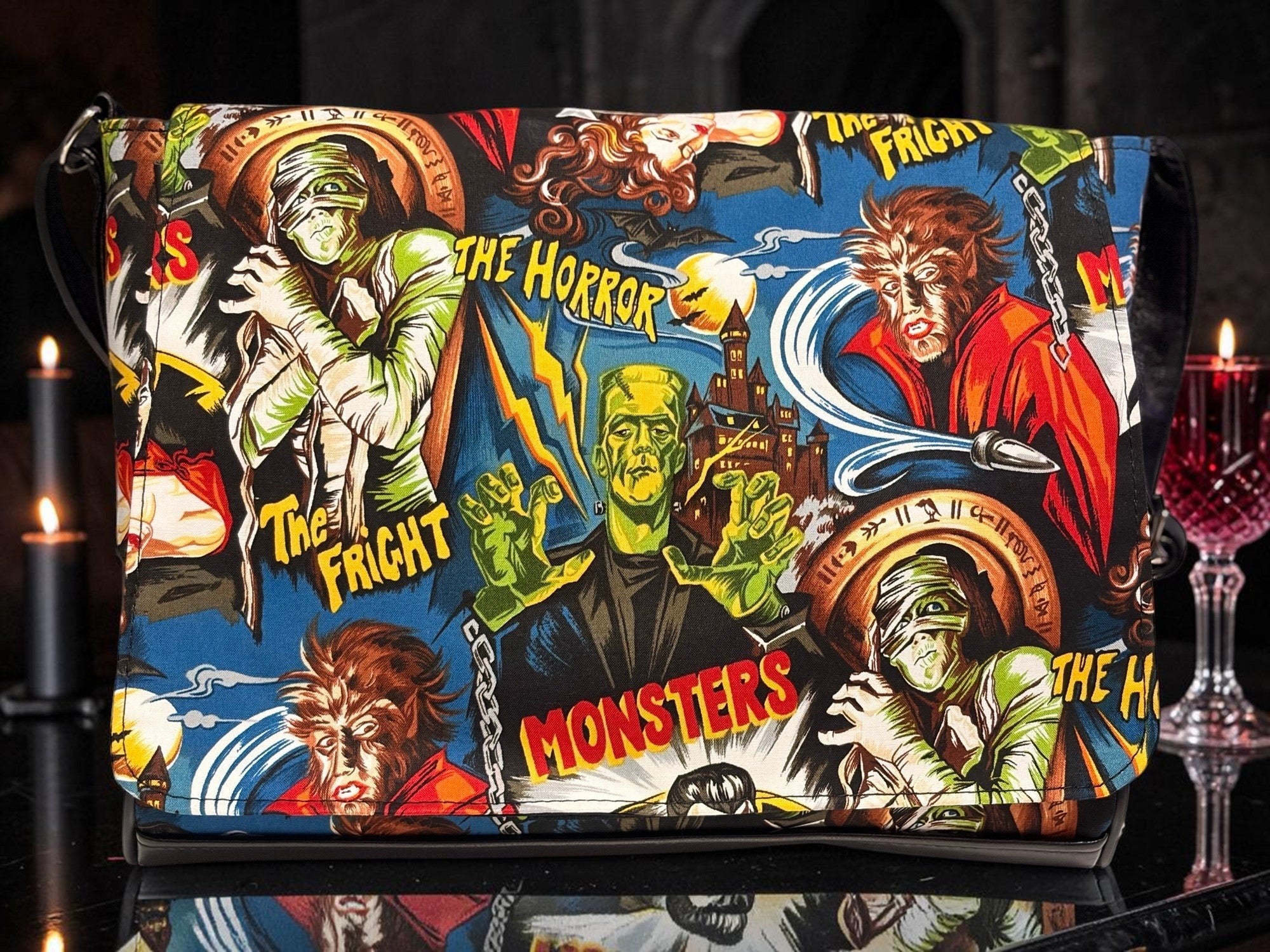 Halloween-Emporium messenger bag featuring a vibrant classic horror movie monster print on a blue background