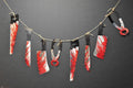 Halloween-Emporium horror party garland featuring blood-stained butcher knives, saws, and pliers on a rustic twine string
