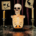 Halloween-Emporium illuminated skeleton torso bust with LED ribcage glow and aged bone finish on a wooden table.