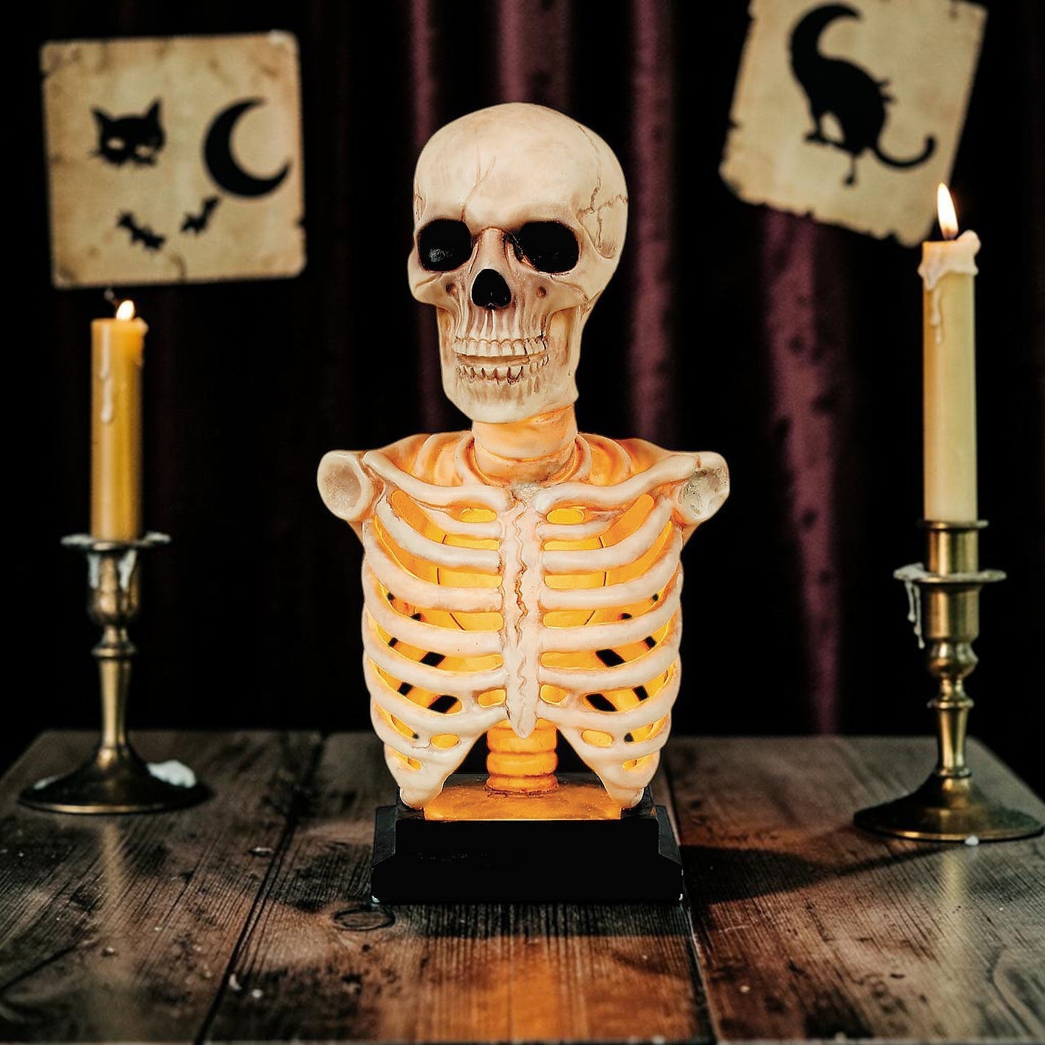 Halloween-Emporium illuminated skeleton torso bust with LED ribcage glow and aged bone finish on a wooden table.
