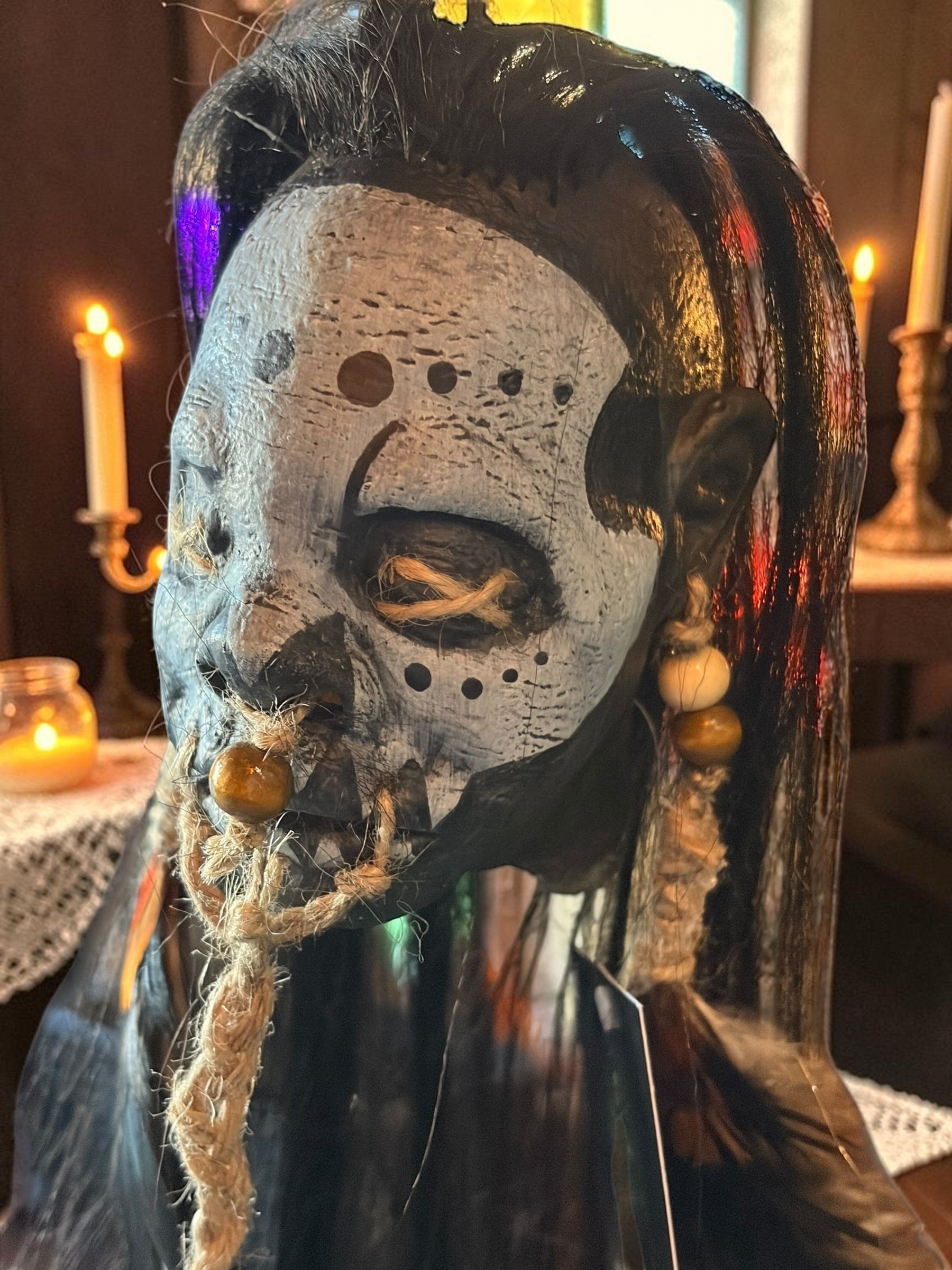 Halloween-Emporium latex voodoo shrunken head mask with tribal markings, synthetic hair, jute rope, and wooden beads.