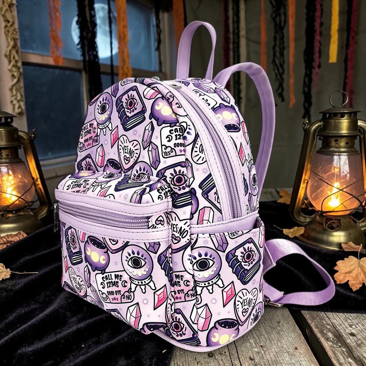 Halloween-Emporium lavender mini backpack with occult symbols like crystal balls and spellbooks in synthetic leather