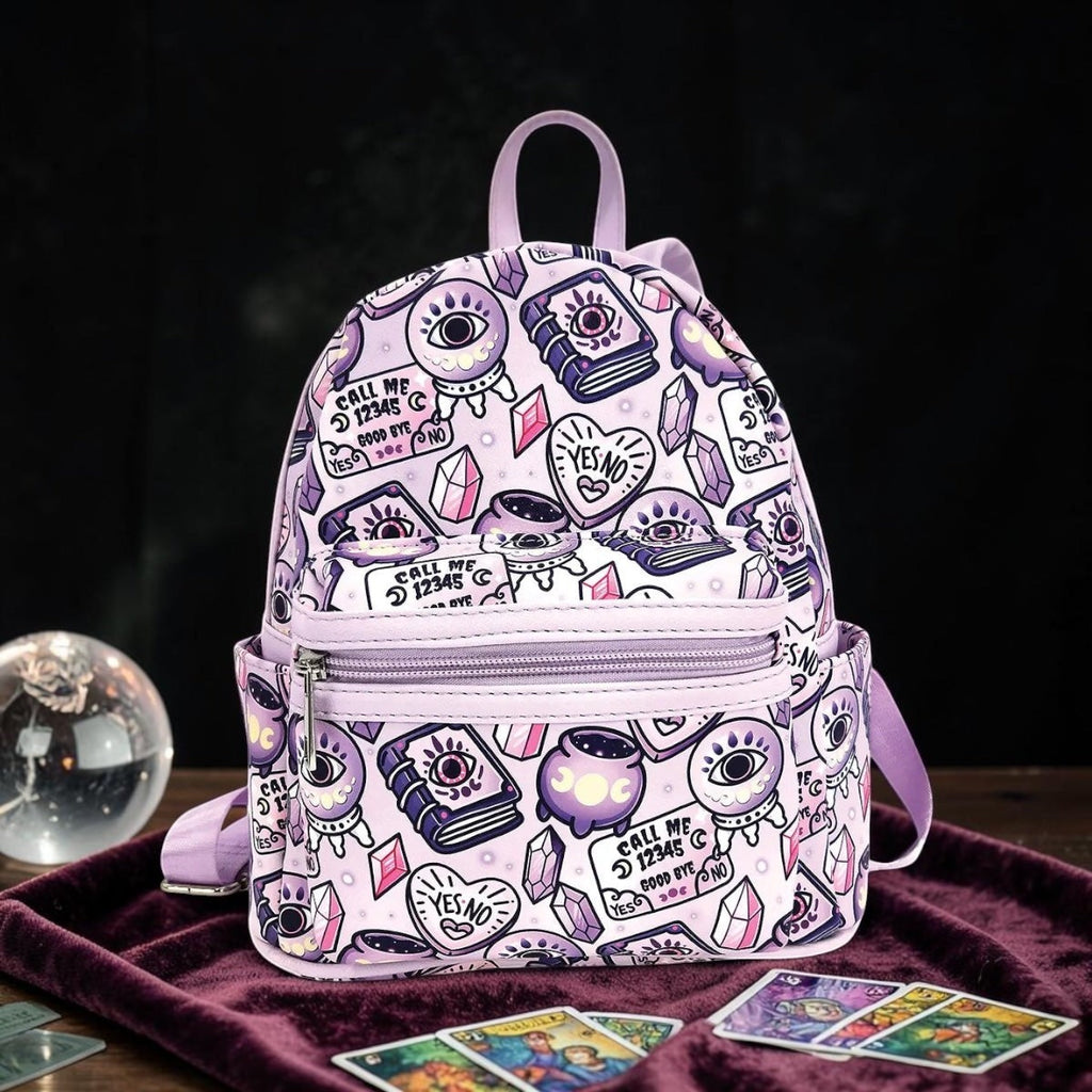 Halloween-Emporium lavender mini backpack with occult symbols like crystal balls and spellbooks on synthetic leather.