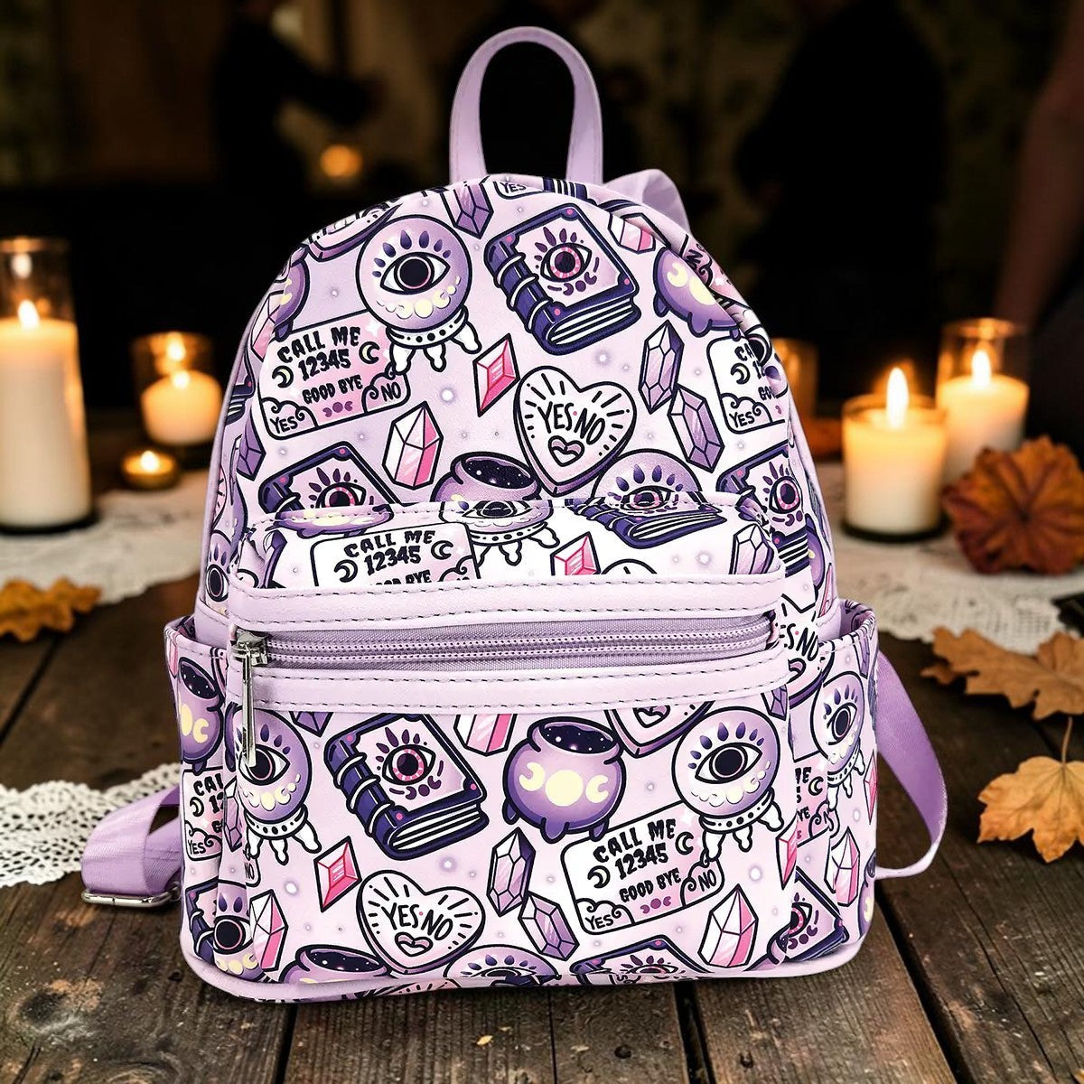Halloween-Emporium lavender mini backpack with mystical occult symbols like crystal balls and cauldrons on leather.