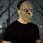 Halloween-Emporium Majo latex horror mask with sharp teeth and detailed skin texture worn by a person in a graveyard.