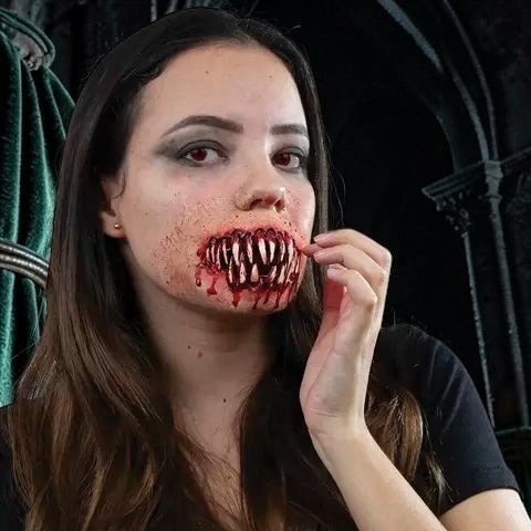 Halloween-Emporium horror monster mouth prosthetic with jagged teeth and bloody gums on a woman for a zombie costume