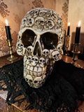 Halloween-Emporium decorative skull container with a mosaic of small skulls and an antique finish on a black cloth.