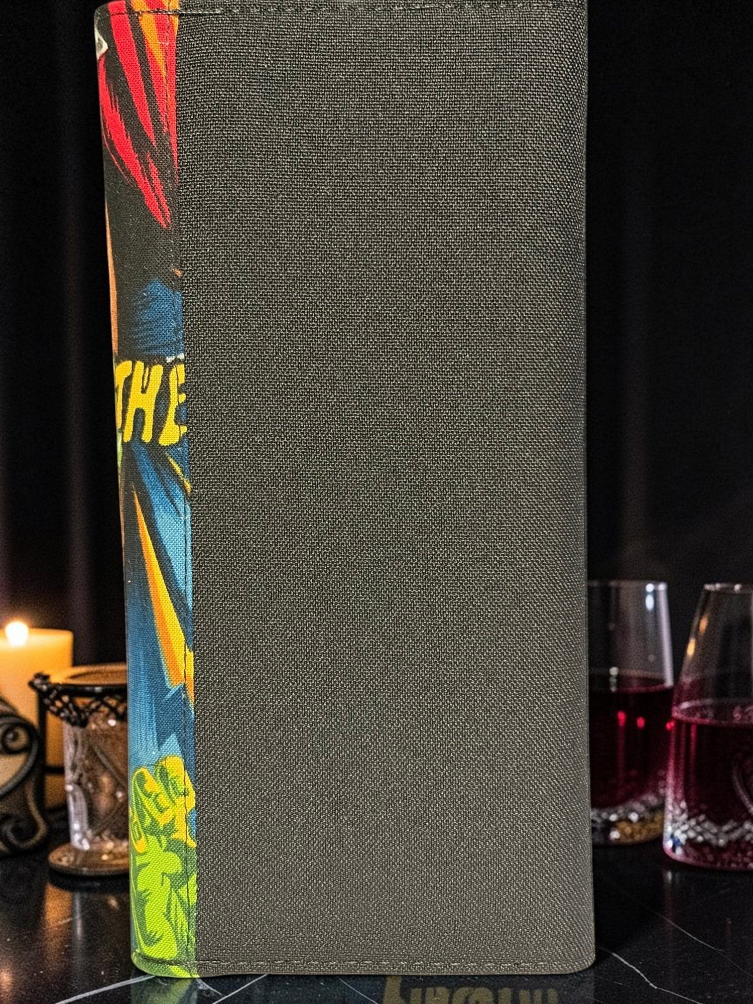 Halloween-Emporium Mummy Clutch Wallet featuring a dark grey textured exterior and a vibrant comic book spine detail.