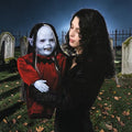 Halloween-Emporium Nocturna vampire puppet with pale latex skin and burgundy velvet gown held by a woman in a graveyard