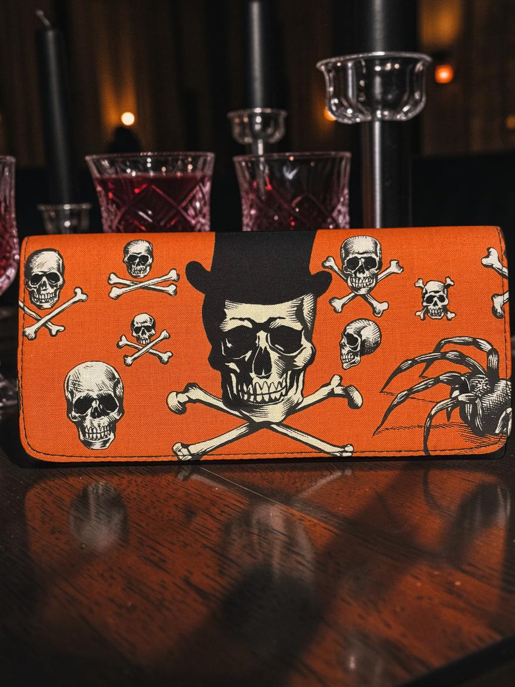 Halloween-Emporium orange clutch wallet featuring a black top hat skull and crossbones print for gothic style.