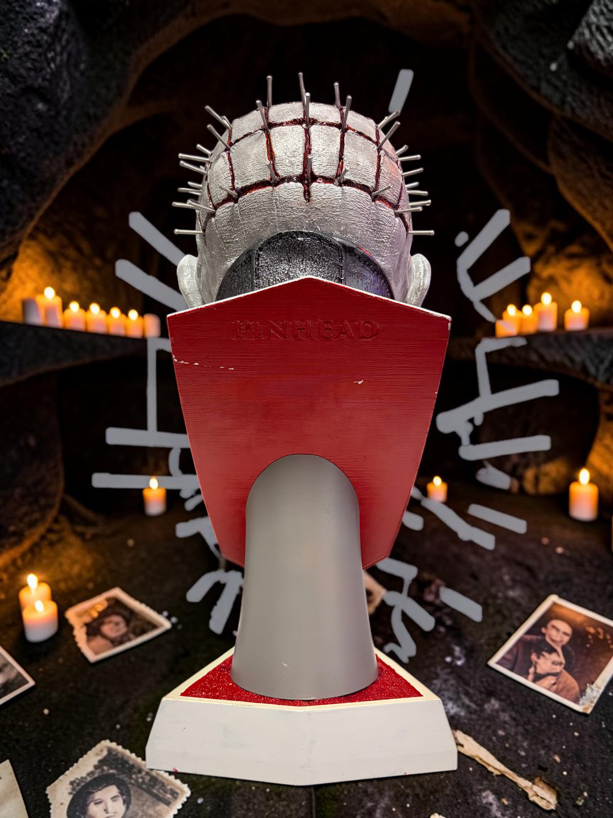 Halloween-Emporium hand painted Pinhead bust with realistic blood effects and textured base in a candlelit setting.