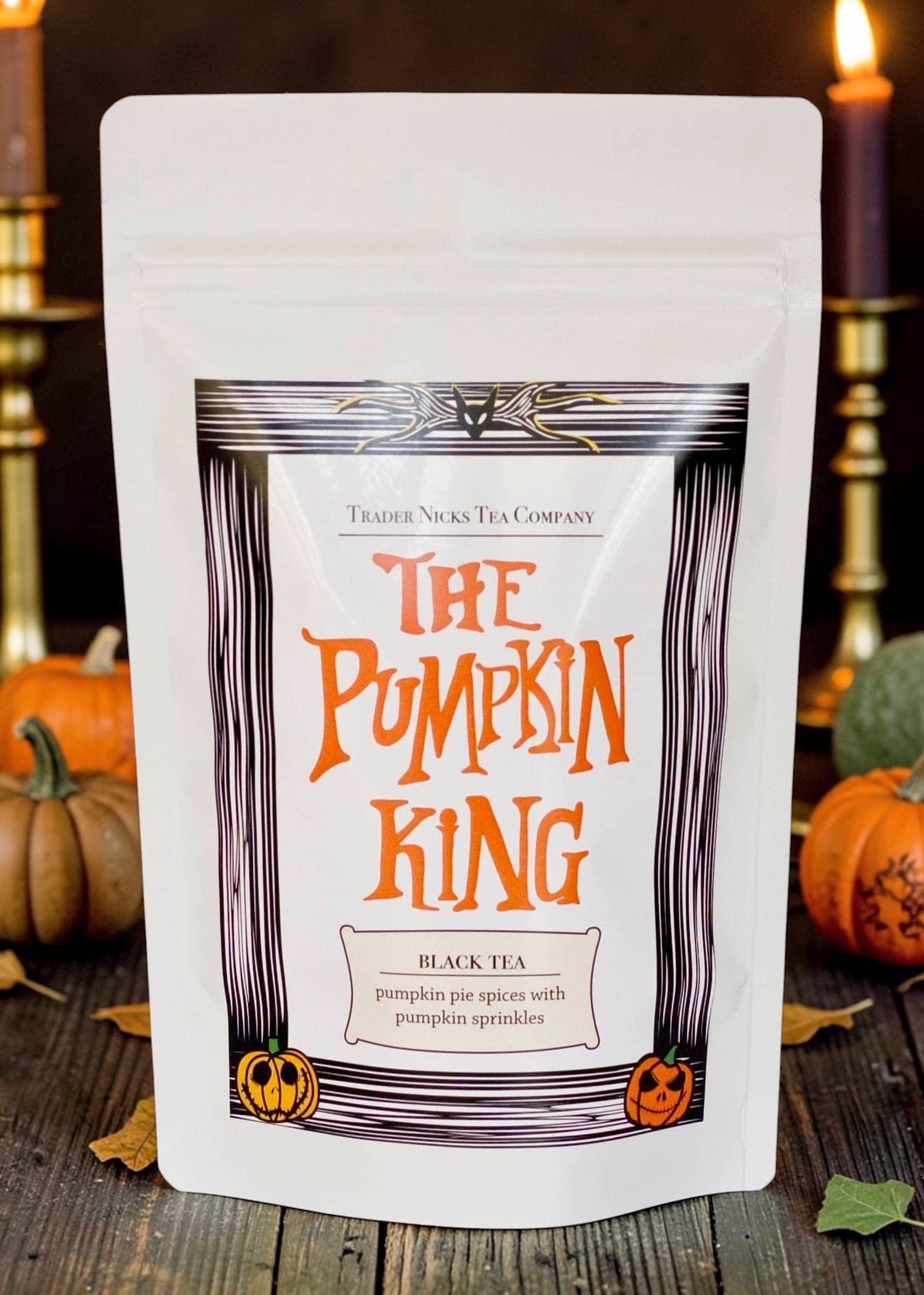 Halloween-Emporium The Pumpkin King black tea pouch with pumpkin pie spices and orange sprinkles on a rustic table.