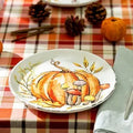 Halloween-Emporium ceramic salad plate featuring a hand-painted orange pumpkin and forest mushrooms on a plaid tablecloth