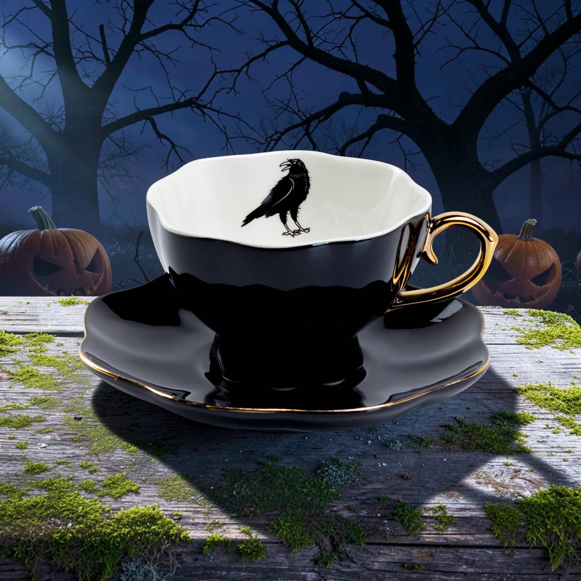 Halloween-Emporium porcelain tea cup and saucer set in glossy black with gold trim and a raven motif inside.