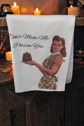 Halloween-Emporium white waffle-weave kitchen towel featuring a retro 1950s housewife illustration and witty text.