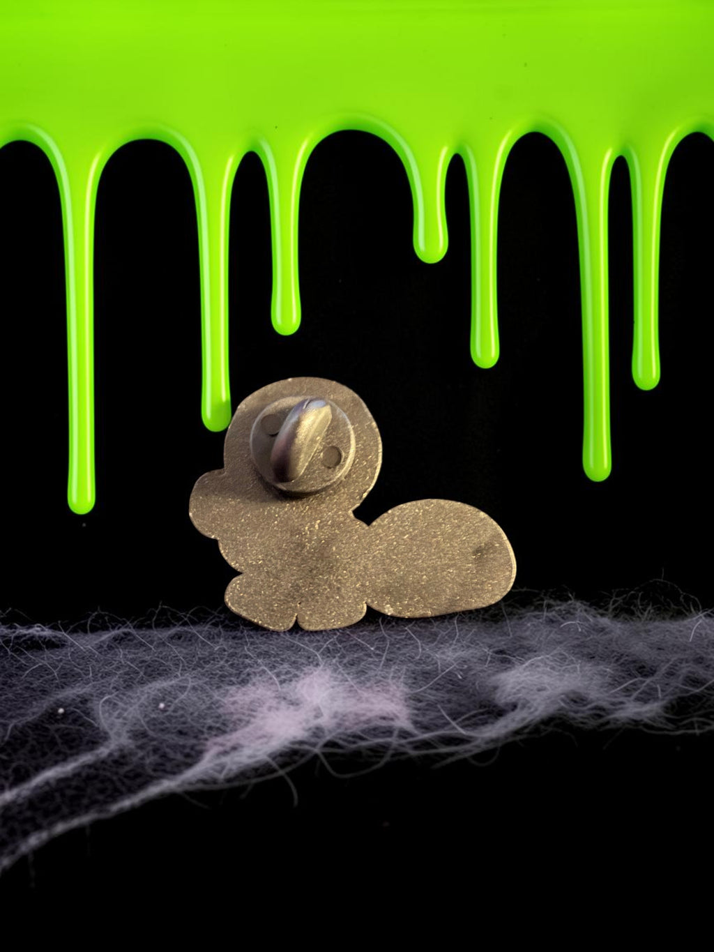 Halloween-Emporium Trick 'r' Treat Sam enamel pin back view showing metal pin post against green slime background