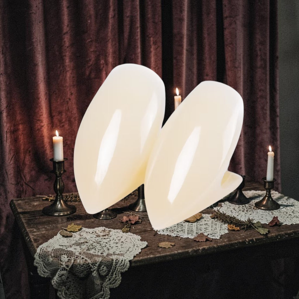 Halloween-Emporium Scarecrow Classic Deluxe vampire fangs in natural off-white color on a dark gothic table setting