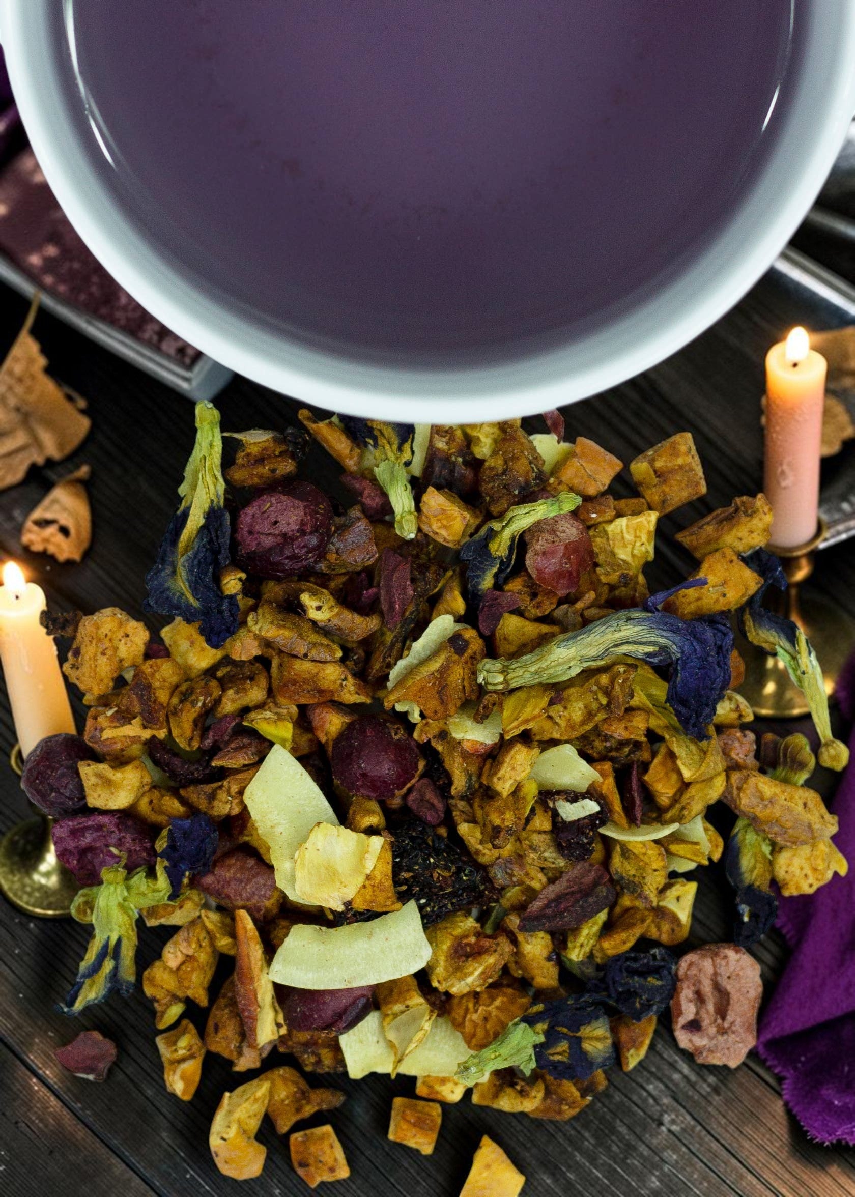 Halloween-Emporium Sea Witch fruit tea blend with dried coconut, cherry, and butterfly pea blossoms next to purple tea.