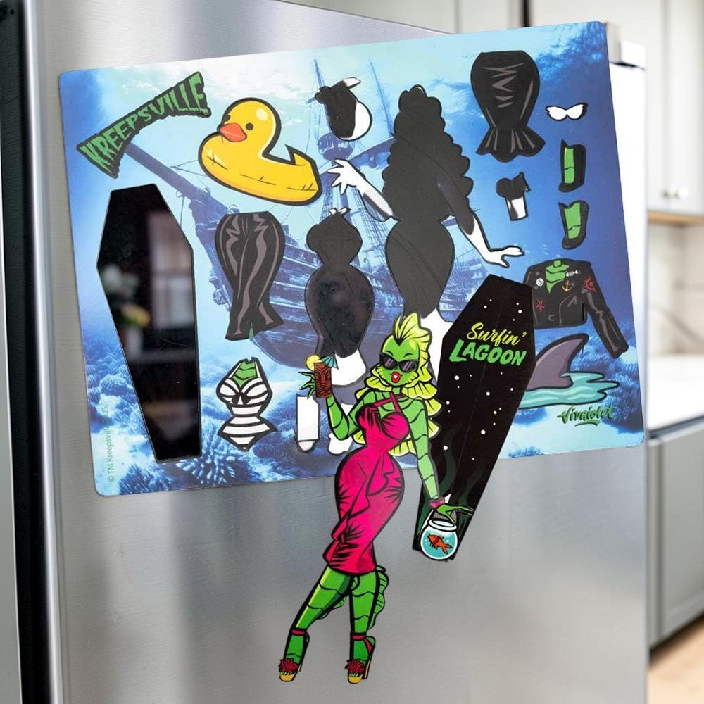 Halloween-Emporium She Creature dress up magnet set featuring a green sea monster character with outfits on a fridge