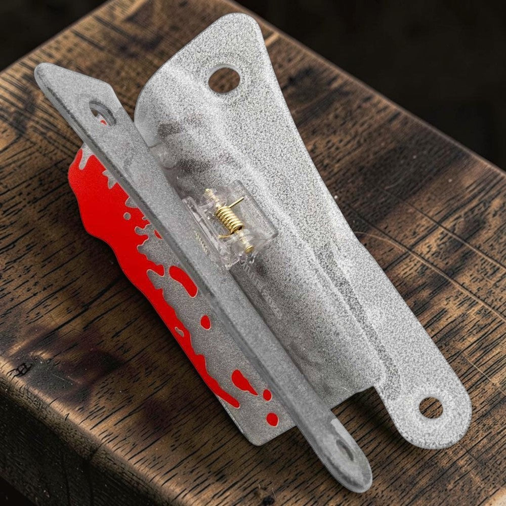Halloween-Emporium silver glitter cleaver hair claw clip with red blood splatter detail on a rustic wooden surface.