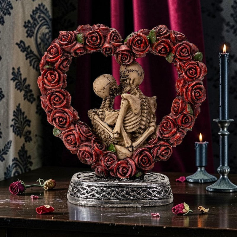 Halloween-Emporium Love Never Dies skeleton couple figurine framed by a red rose heart on a Celtic knotwork base.