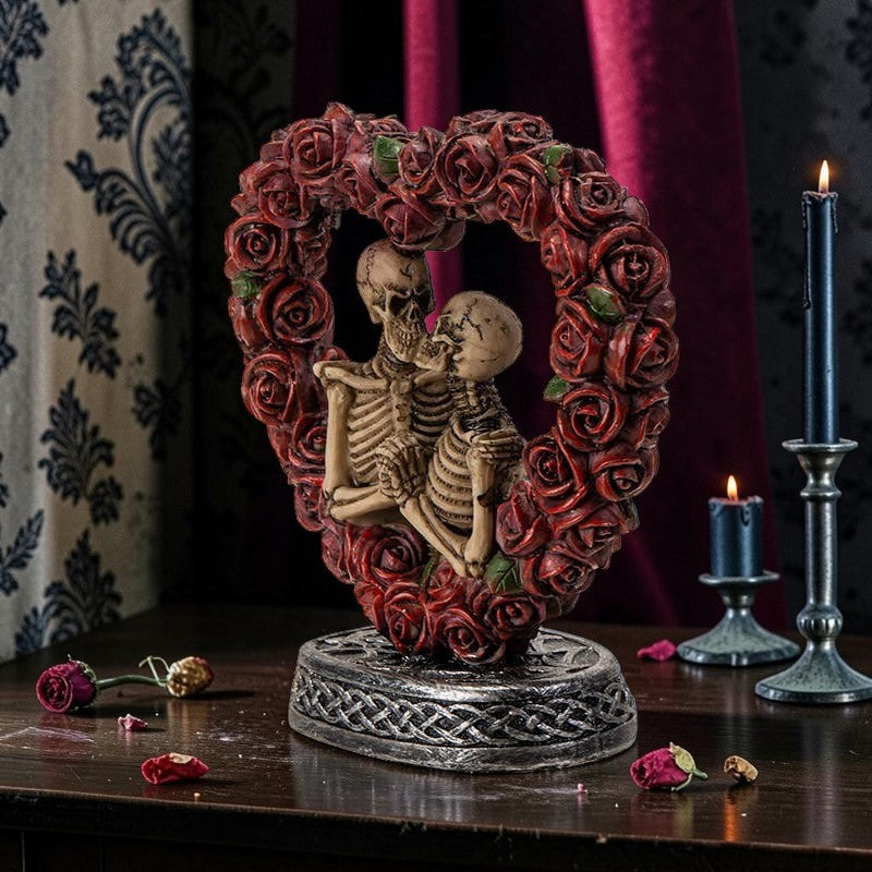 Halloween-Emporium Love Never Dies skeleton couple figurine framed by a red rose heart on a Celtic knotwork base.