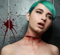 Halloween-Emporium latex slit throat SFX appliance on a model with teal hair against a blood-splattered tiled wall