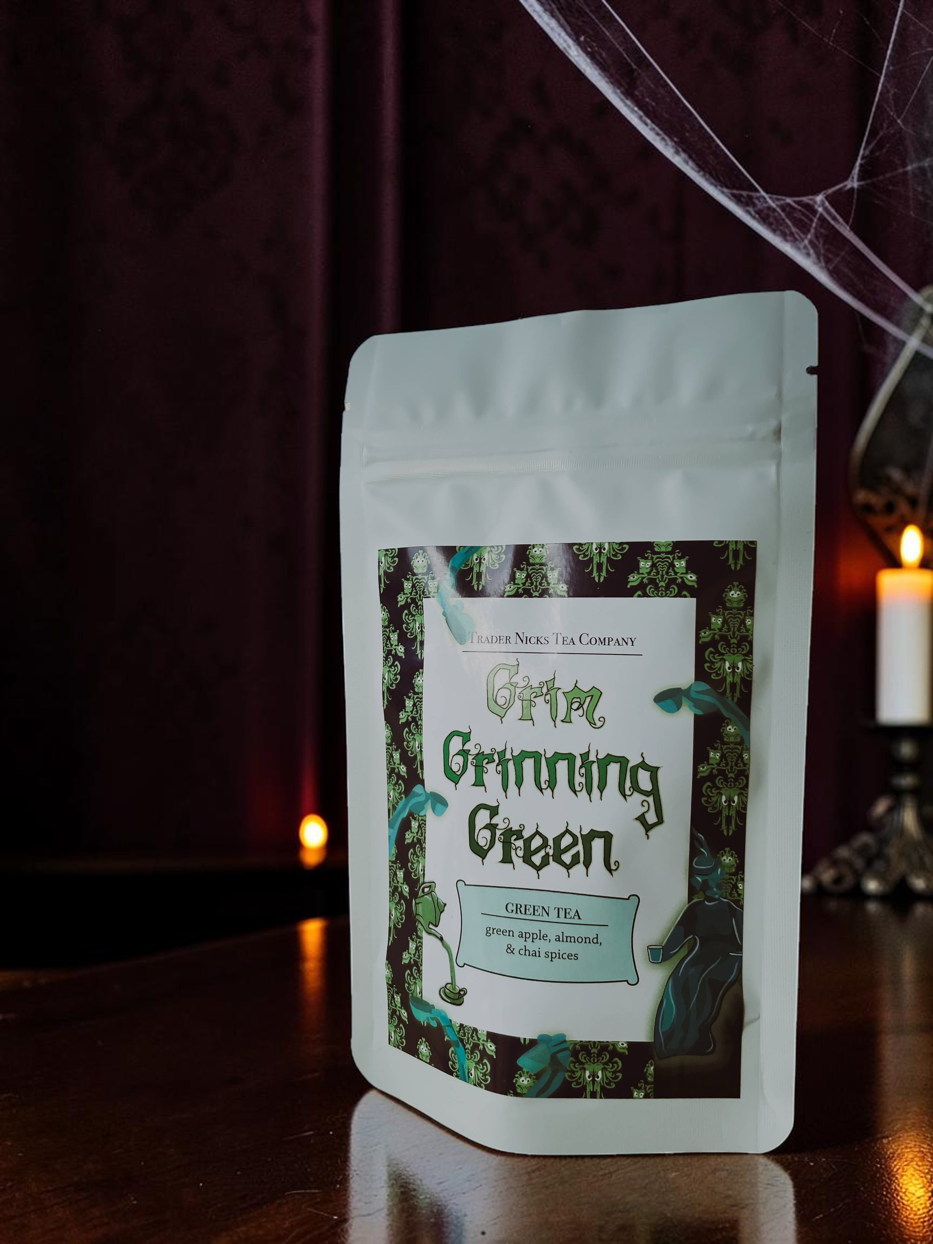 Halloween-Emporium Grim Grinning Green spiced apple green tea pouch with spooky graveyard label in a dark setting