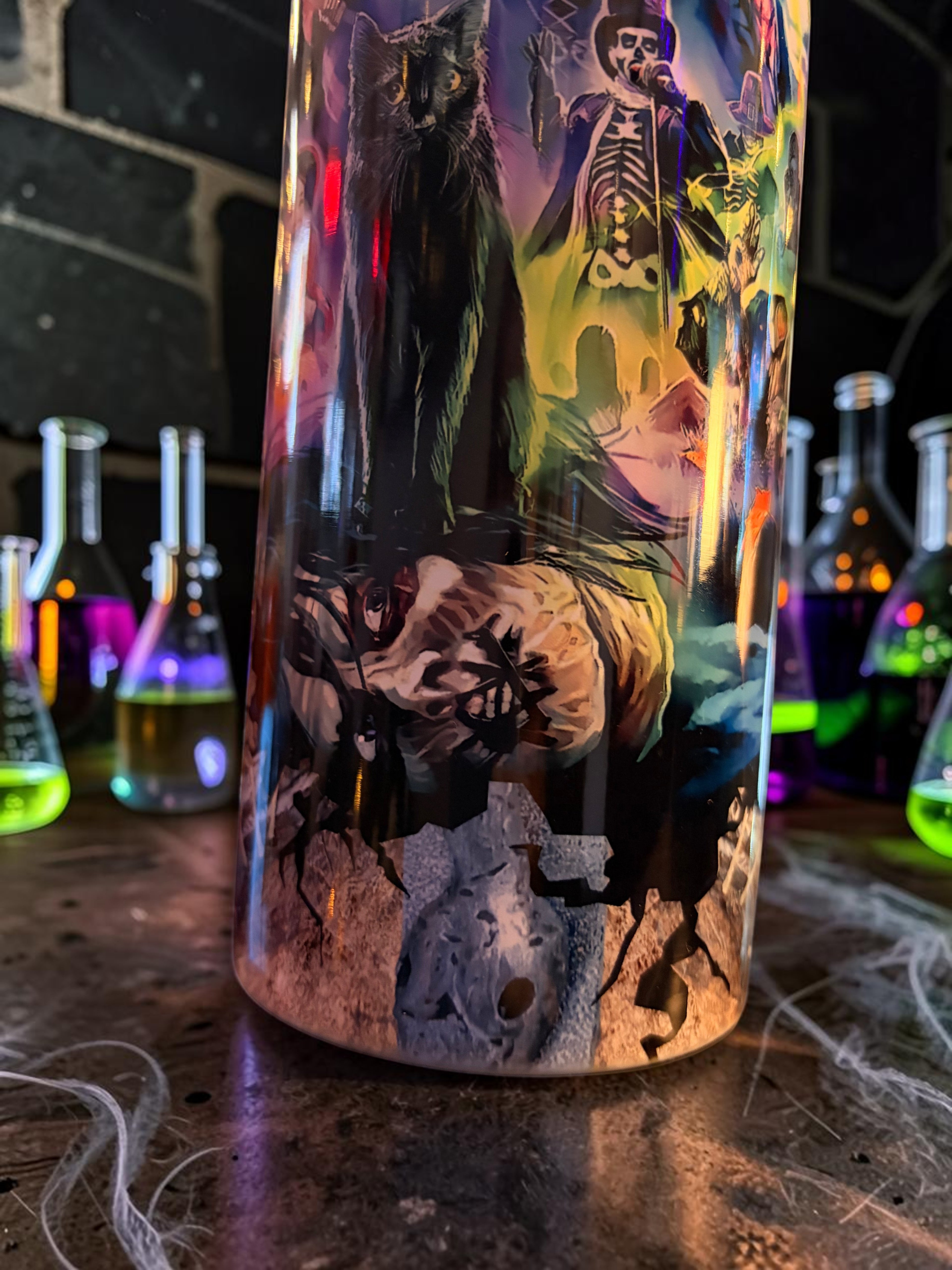 Halloween-Emporium 30oz tumbler featuring a dark-luxe graphic of a black cat and skeleton in a spooky graveyard scene.