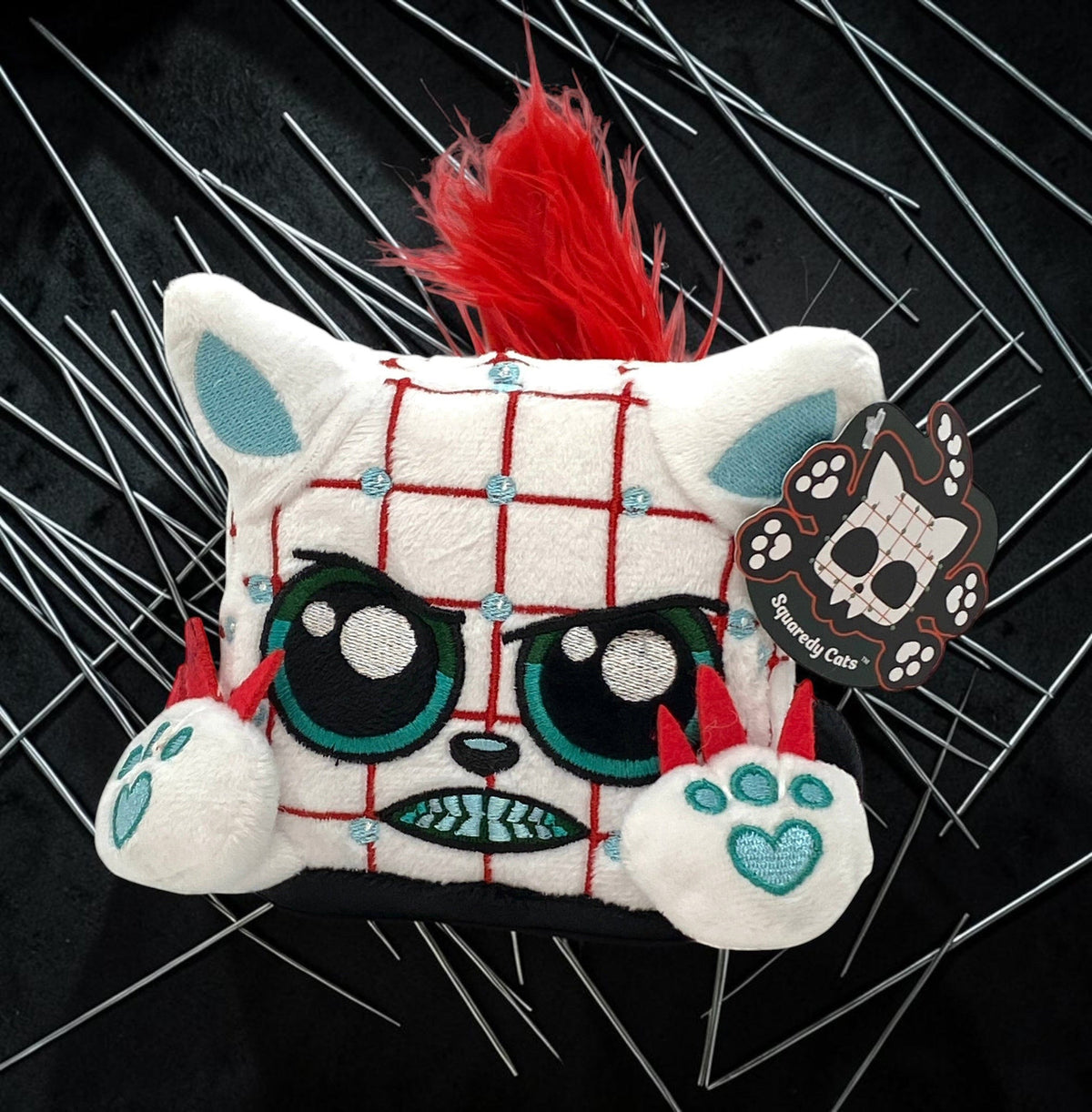 Halloween-Emporium Squaredy Cats horror plush toy with white grid pattern, red faux-fur tail, and teal claw details.