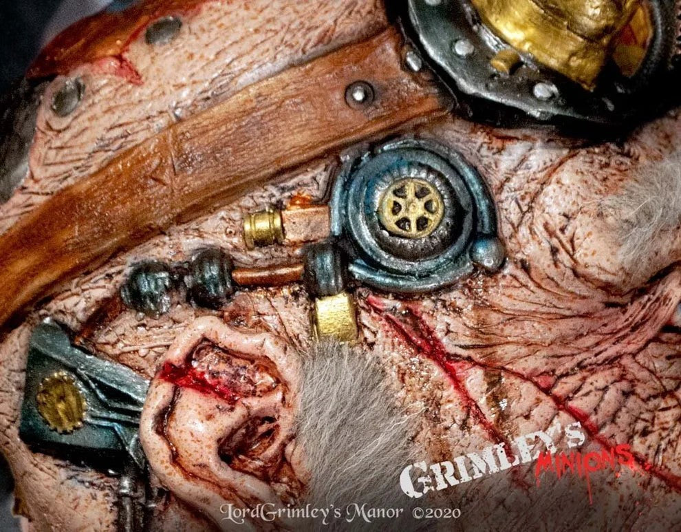 Halloween-Emporium steampunk inventor mask with weathered skin, brass goggles, and intricate mechanical gear details.