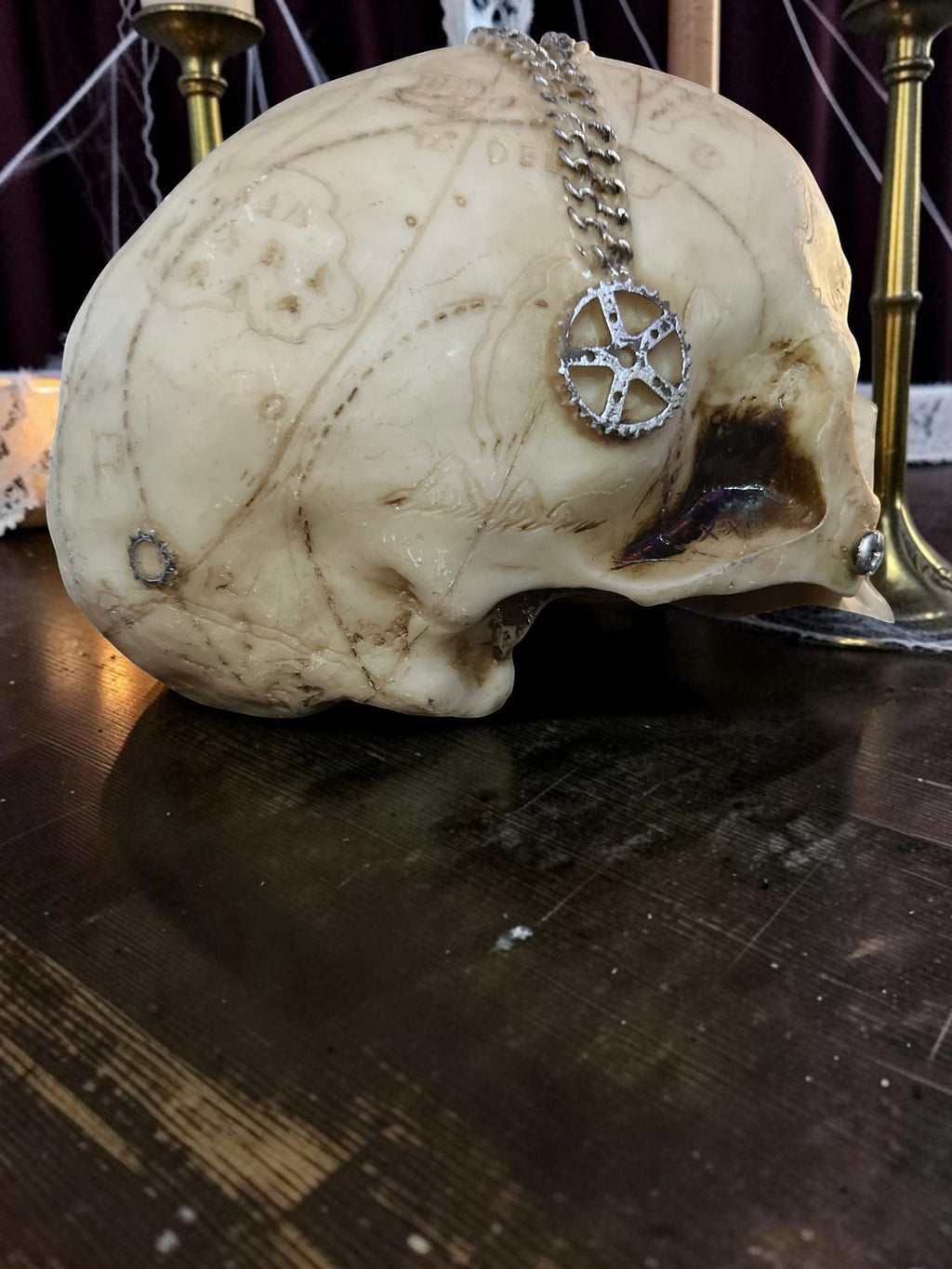 Halloween-Emporium steampunk mechanical skull decoration with aged bone finish and silver gear chain accent