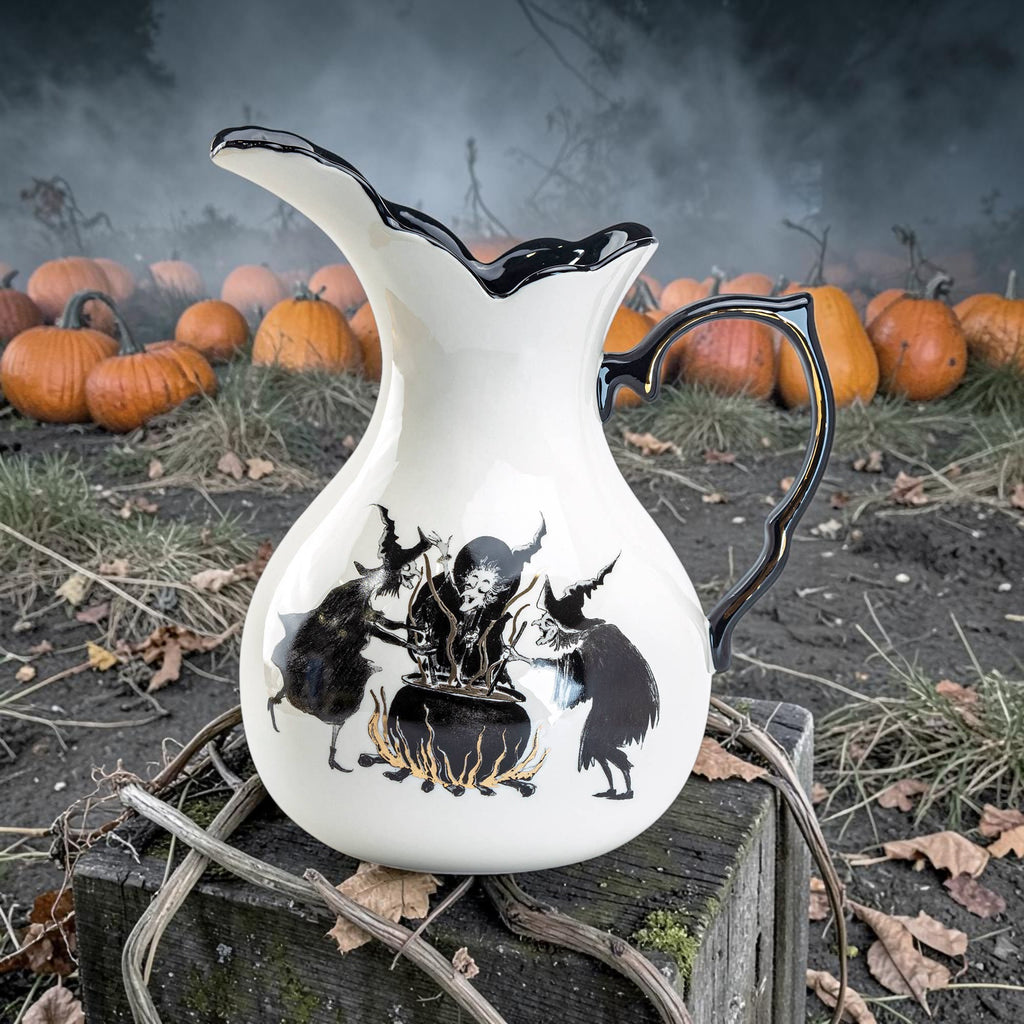 Halloween-Emporium stoneware witches brew pitcher with black interior, raven and cauldron art, and gold detailing.