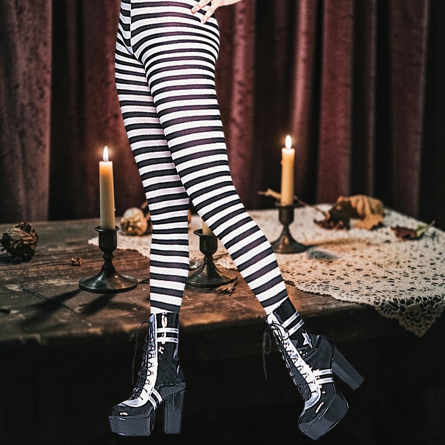 Halloween-Emporium black and white horizontal striped costume leggings worn with platform boots in a spooky setting