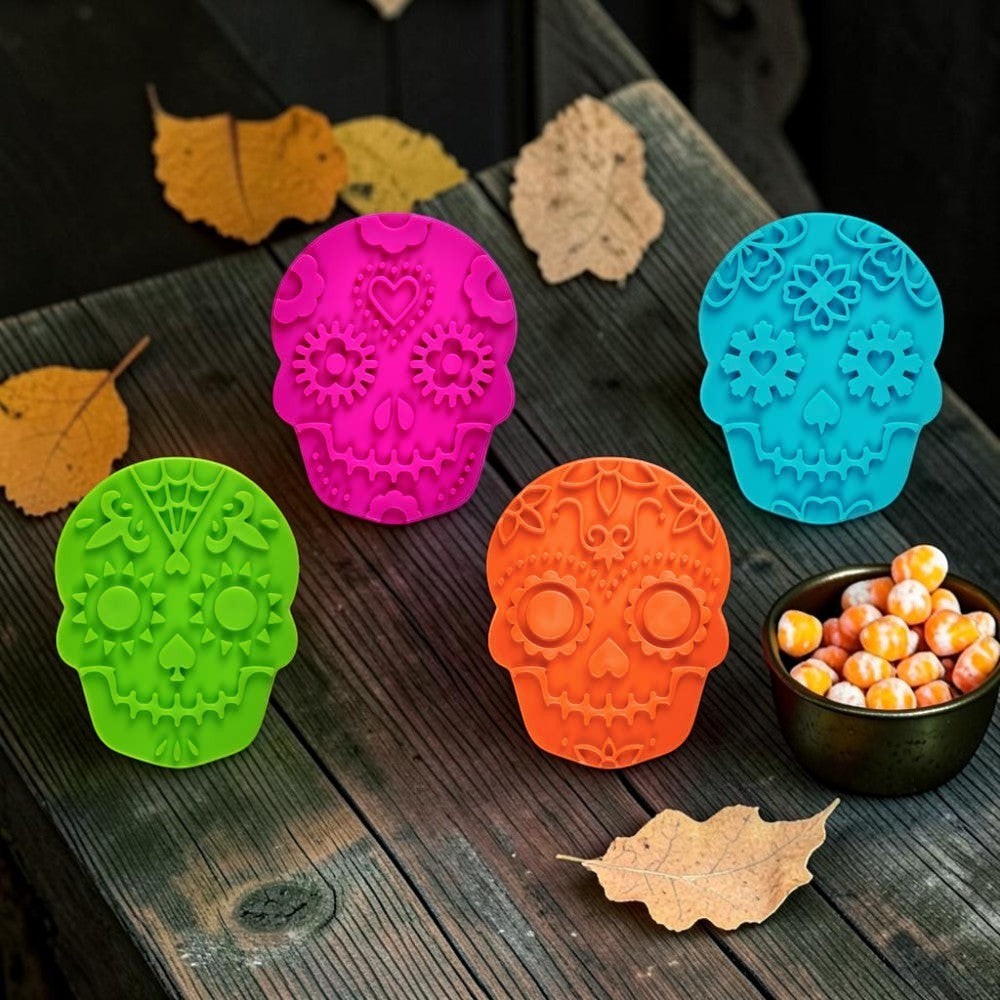 Halloween-Emporium Sweet Spirits sugar skull cookie cutters in pink, blue, green, and orange on a wooden table.