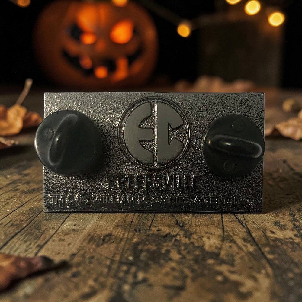 Halloween-Emporium Tales From The Crypt enamel pin back view showing dual-pin clutch system on a rustic wooden table.