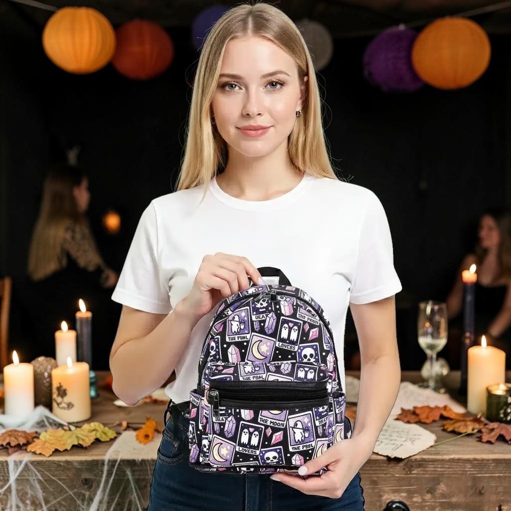 Halloween-Emporium mini backpack with purple and black tarot card print, featuring crystals and ghosts on a model.