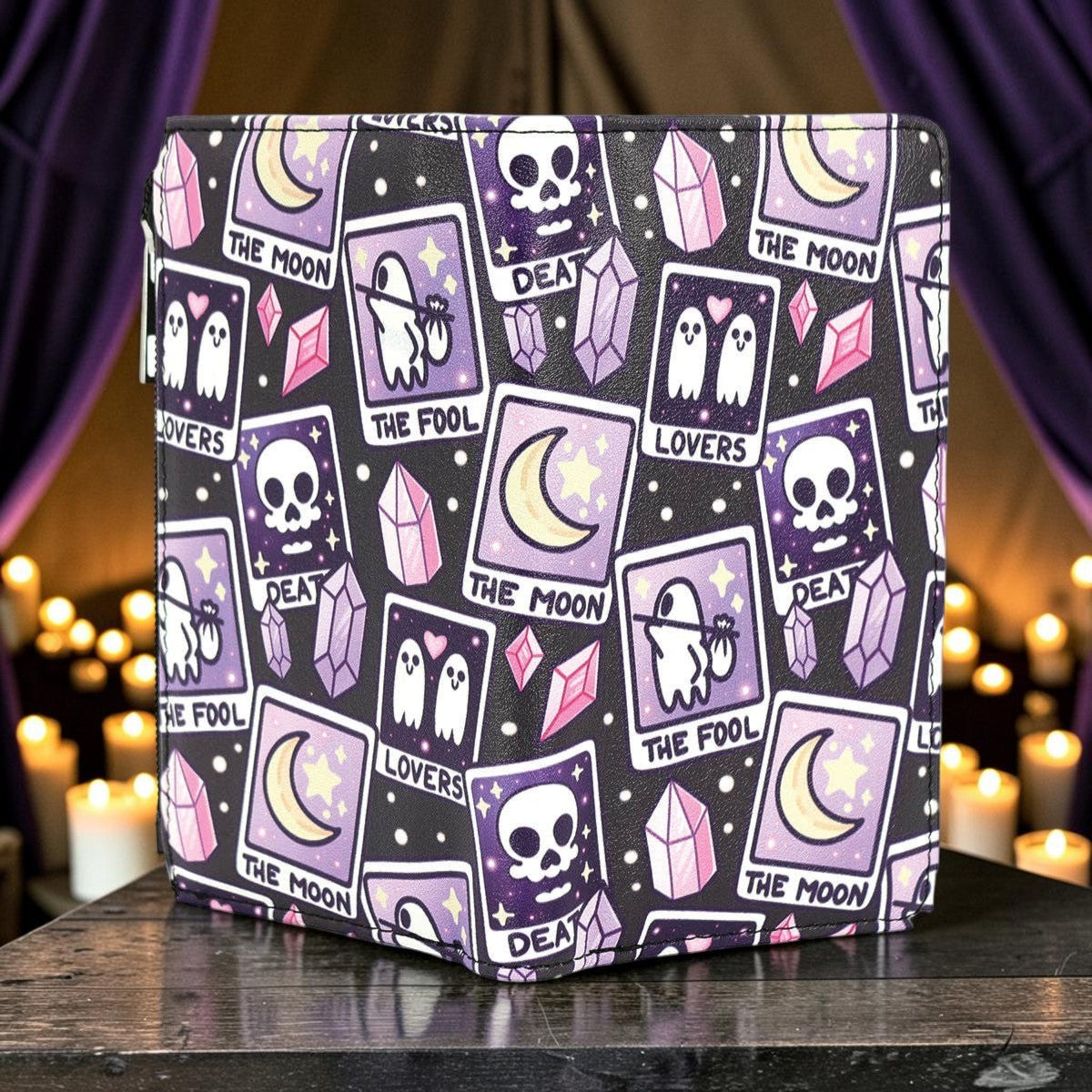 Halloween-Emporium tarot card print vinyl wallet featuring purple and black gothic motifs on a dark table.